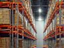 Innenansicht eines modernen Lagerhauses mit Regalen, symbolisiert Lagerung & Warehousing